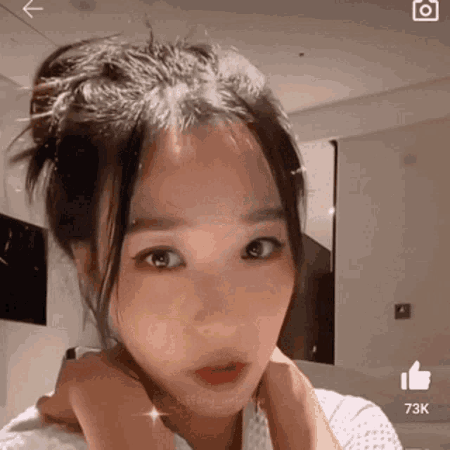 a close up of a woman 's face with a 73k thumbs up