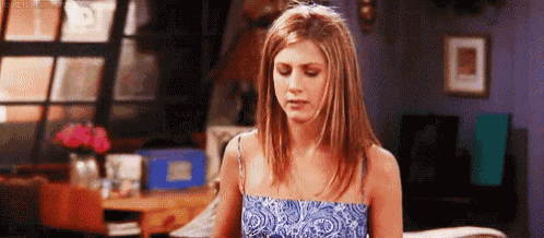 a woman in a blue dress is standing in a living room with her eyes closed .