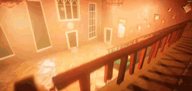 a person is walking down a wooden staircase in a room with a red railing .