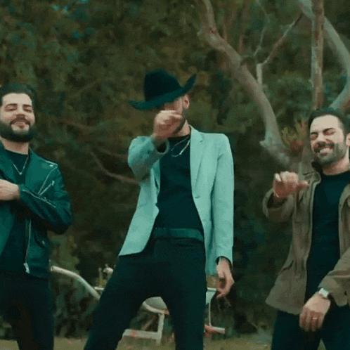 a man in a cowboy hat is dancing with another man in a jacket
