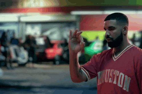 a man wearing a red houston jersey is waving