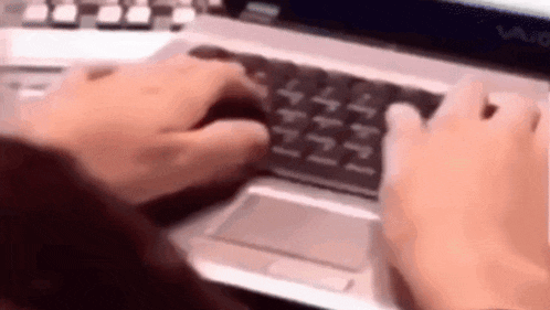 a person is typing on a laptop with a mouse and keyboard .