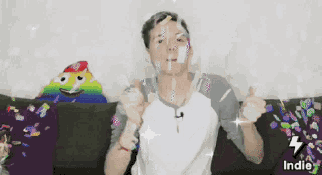 a man is sitting on a couch with confetti falling around him and the words indie on the bottom right