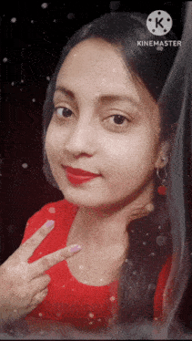 a woman in a red shirt is giving the peace sign