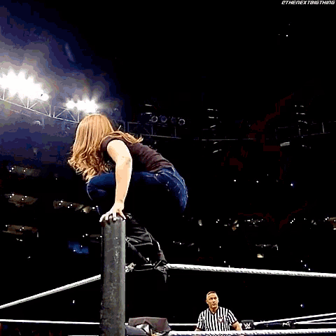 a wrestler is doing a handstand in front of a sign that says ' wrestling game '