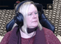 a woman wearing headphones is sitting in a chair and looking at the camera .