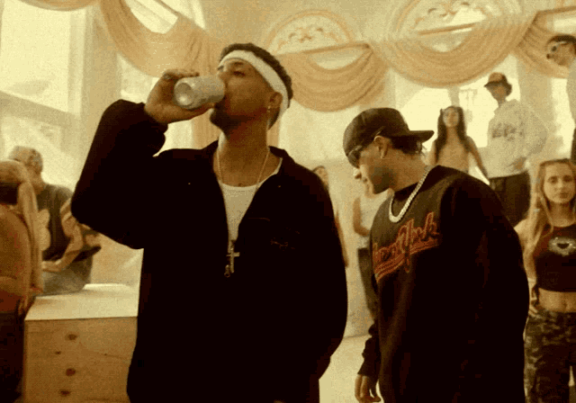 a man drinking from a can while wearing a sweatshirt that says ' rock n ' roll ' on it