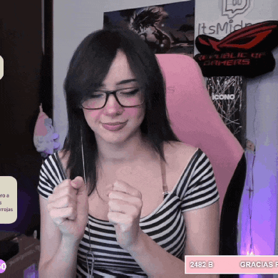 a woman wearing glasses and a striped shirt is sitting in front of a pink chair that says republic of gamers on it