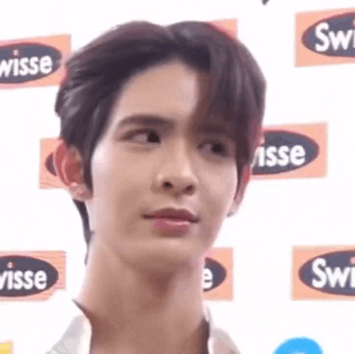 a close up of a young man 's face with a serious expression .