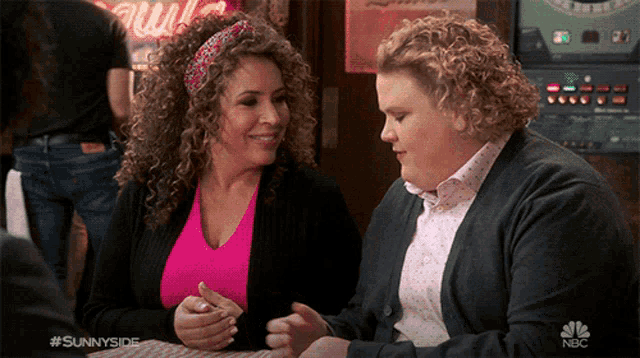 two women are sitting at a table with nbc written on the bottom
