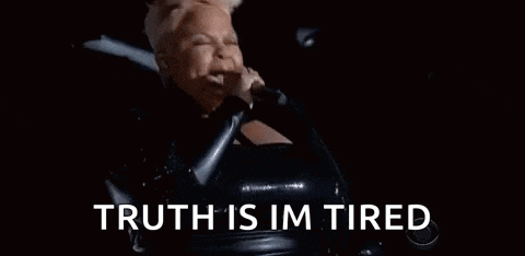 a woman is singing into a microphone with the words `` truth is im tired '' .