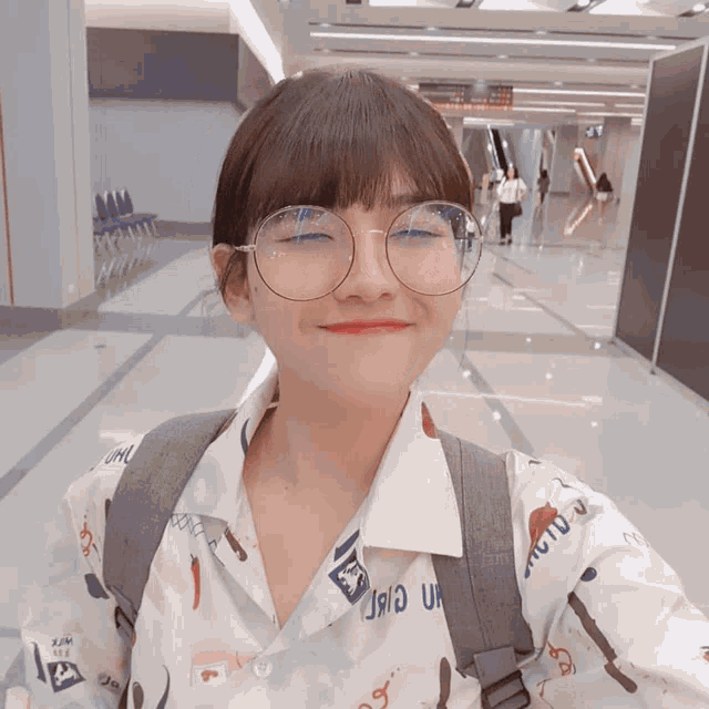 a woman wearing glasses and a shirt that says ' uio ' on it