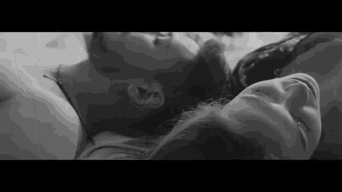 a man and a woman are laying next to each other on a bed .