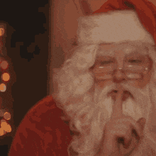 a close up of santa claus 's face with glasses and a beard