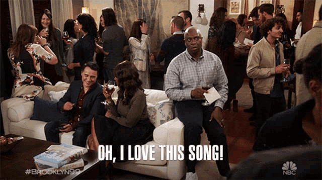 a man sitting on a couch says oh i love this song in front of a crowd