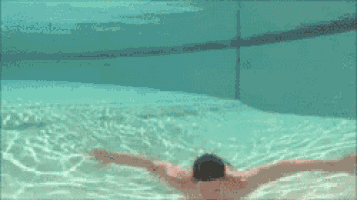 a child is swimming underwater in a pool