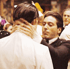 a man in a tuxedo is hugging another man