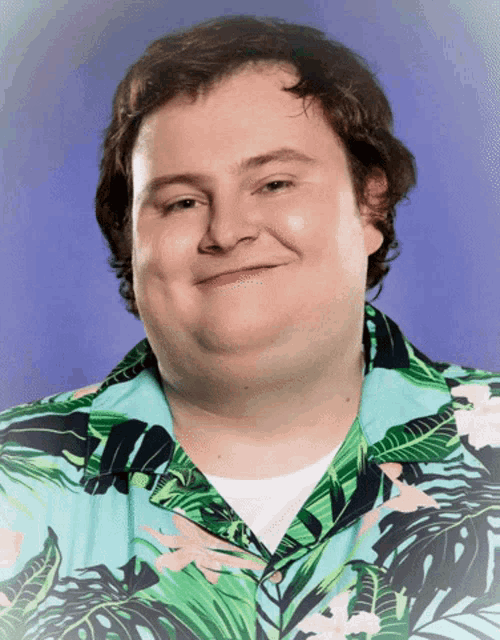 a man wearing a hawaiian shirt is smiling and looking at the camera