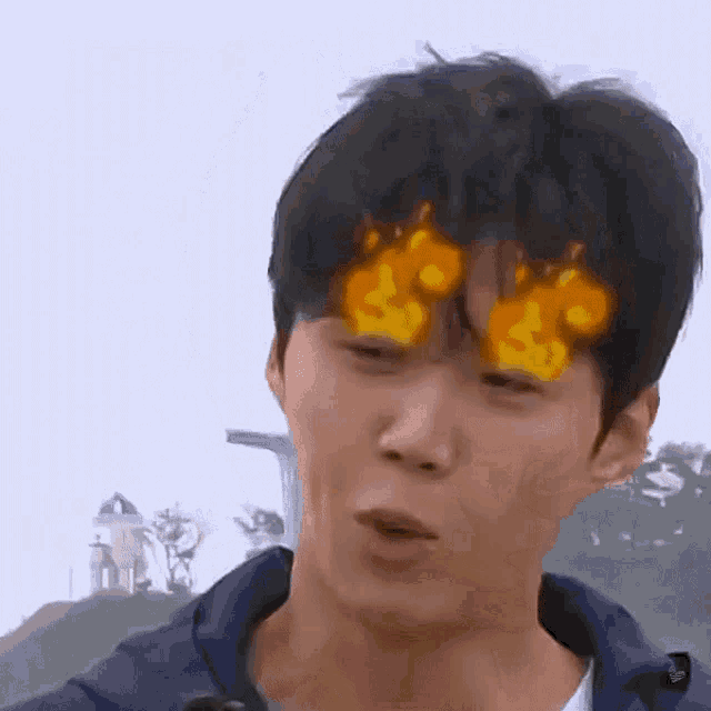 a close up of a person 's face with fire coming out of his eyes .