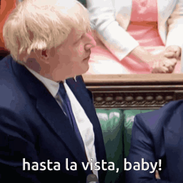 a man in a suit and tie with the words hasta la vista baby behind him