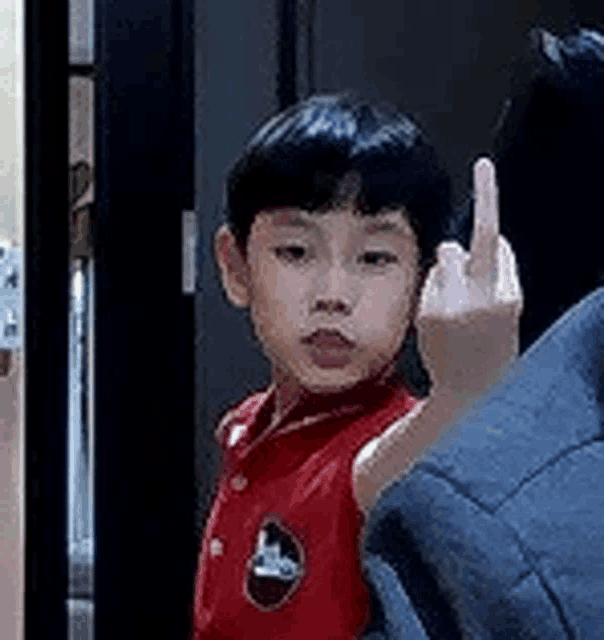 a young boy is giving the middle finger to a man .