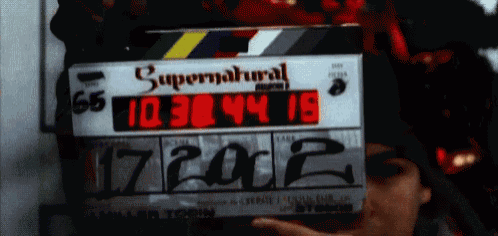 a person is holding a clapper board that says supernatural