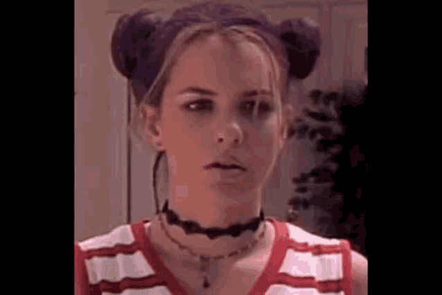a young woman with purple hair and two buns is wearing a choker and a striped shirt .