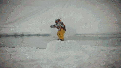 a person standing on top of a snow covered pile