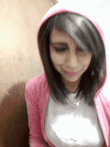 a girl wearing a pink hoodie is smiling