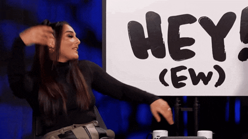 a woman sitting in front of a sign that says hey ew