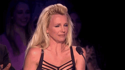 a blonde woman in a black bra is crying while speaking into a microphone