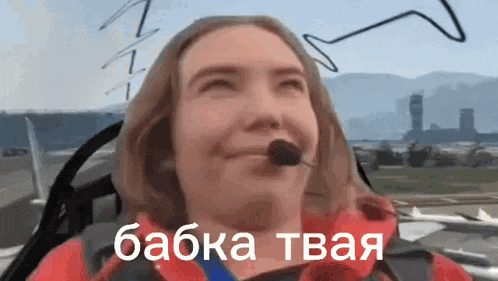 a woman is sitting in a cockpit of an airplane with a microphone .