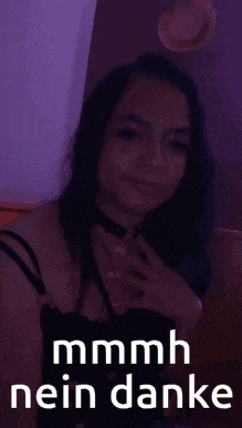 a woman wearing a choker and a black top is sitting in a dark room with a purple light behind her .