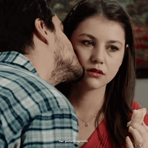 a man kisses a woman on the cheek with the twitter username pistachiogrentv visible