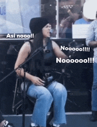 a woman sitting in front of a microphone with the words " asi nooo " and " noooo " above her