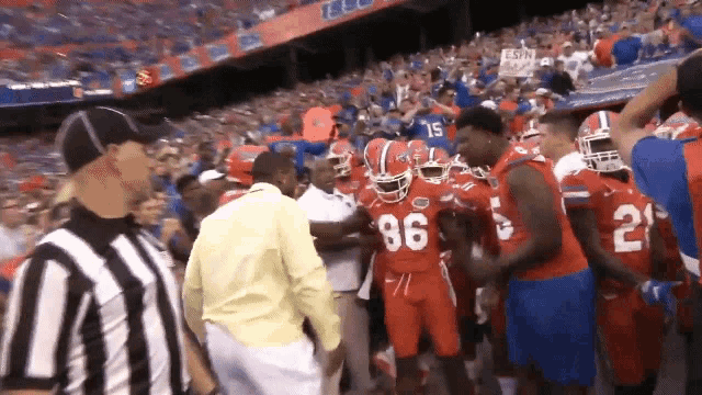 a group of football players are standing in a stadium with a sign that says espn on it