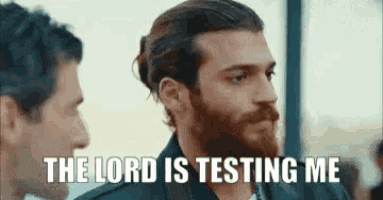 a man with a beard is standing next to another man and talking to him .