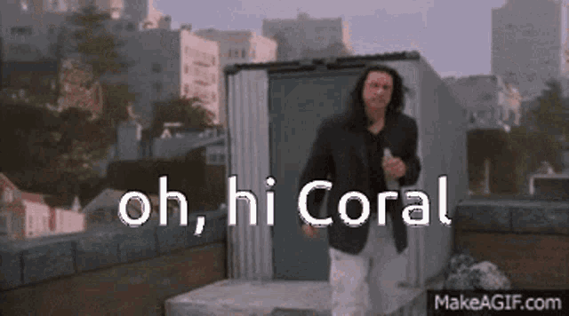 a man in a suit says oh hi coral in front of a shed
