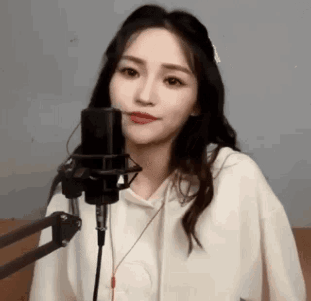 a woman is singing into a microphone in a studio .