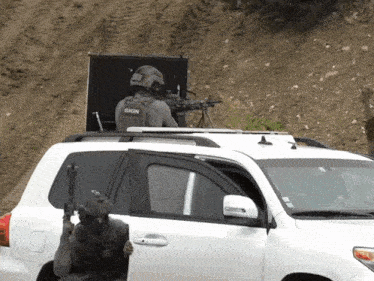 a man in a gign vest is standing in front of a white suv