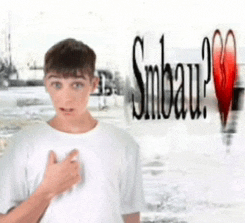 a young man in a white shirt stands in front of a sign that says smbau