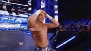 a shirtless wrestler stands in front of a sign that says mackdown