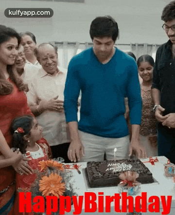 a group of people standing around a birthday cake with the words happy birthday written on it