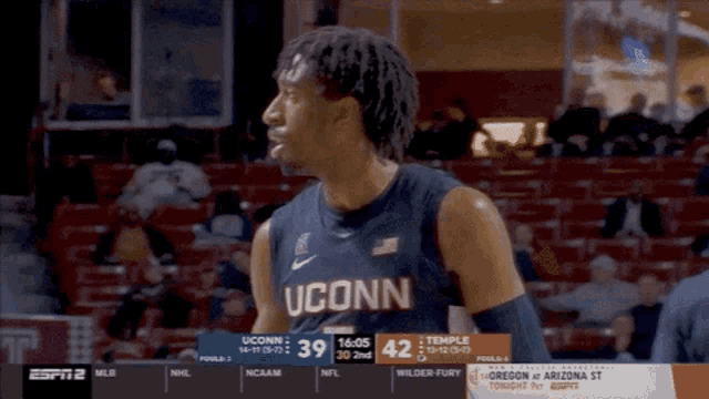 a uconn basketball player stands in the stands