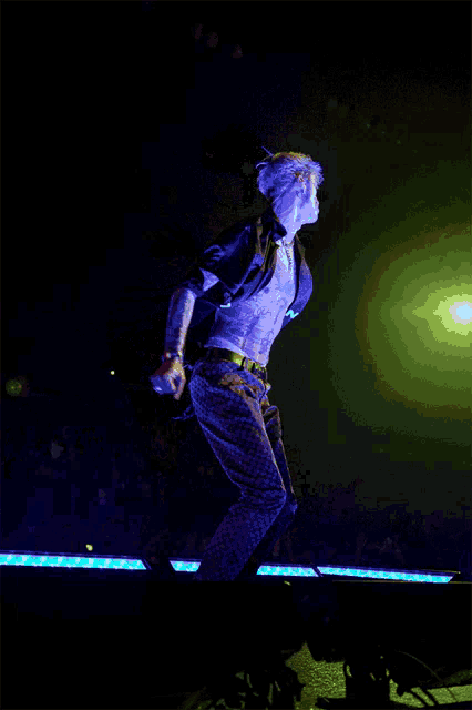 a man is jumping in the air while wearing a shirt that says ' a ' on it