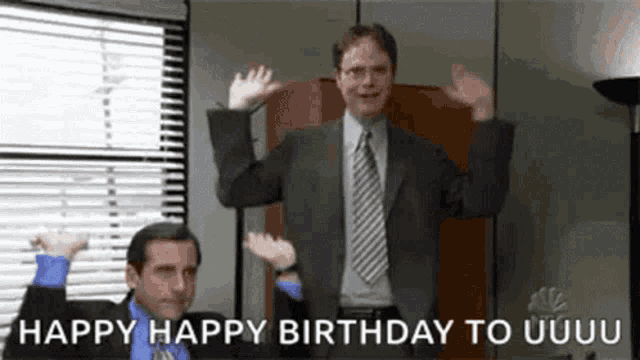a man in a suit and tie is dancing in an office while another man says happy birthday to u .