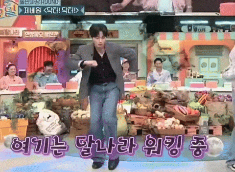 a man in a suit is dancing in front of a sign that says cafe