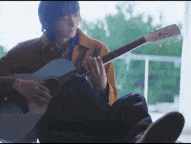 a person playing a guitar with the letter a on the headstock