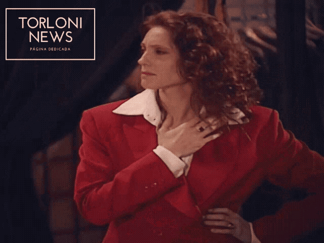 a woman in a red suit is covering her face with her hand in front of a torloni news banner