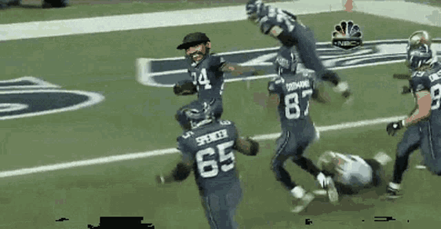 a football player with the number 65 on his jersey is running on the field